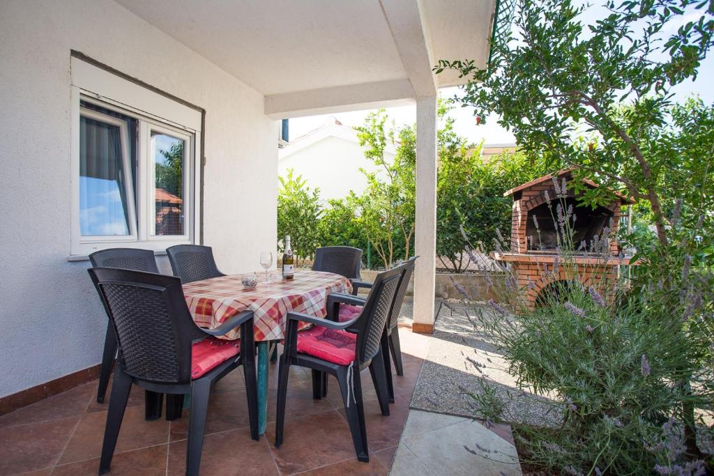 a table and chairs sitting on a patio at Apartments Mala Karla 1685 in Seget Vranjica