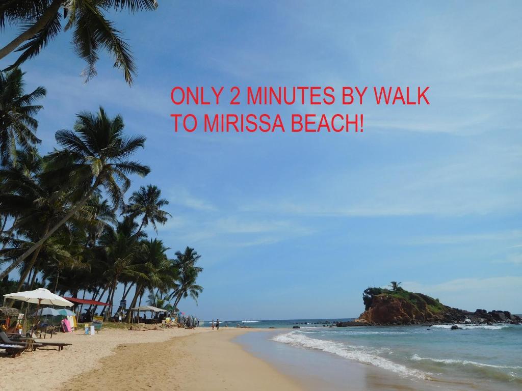 a beach with palm trees and the ocean with the words only minutes by walk at Our World Mirissa in Mirissa