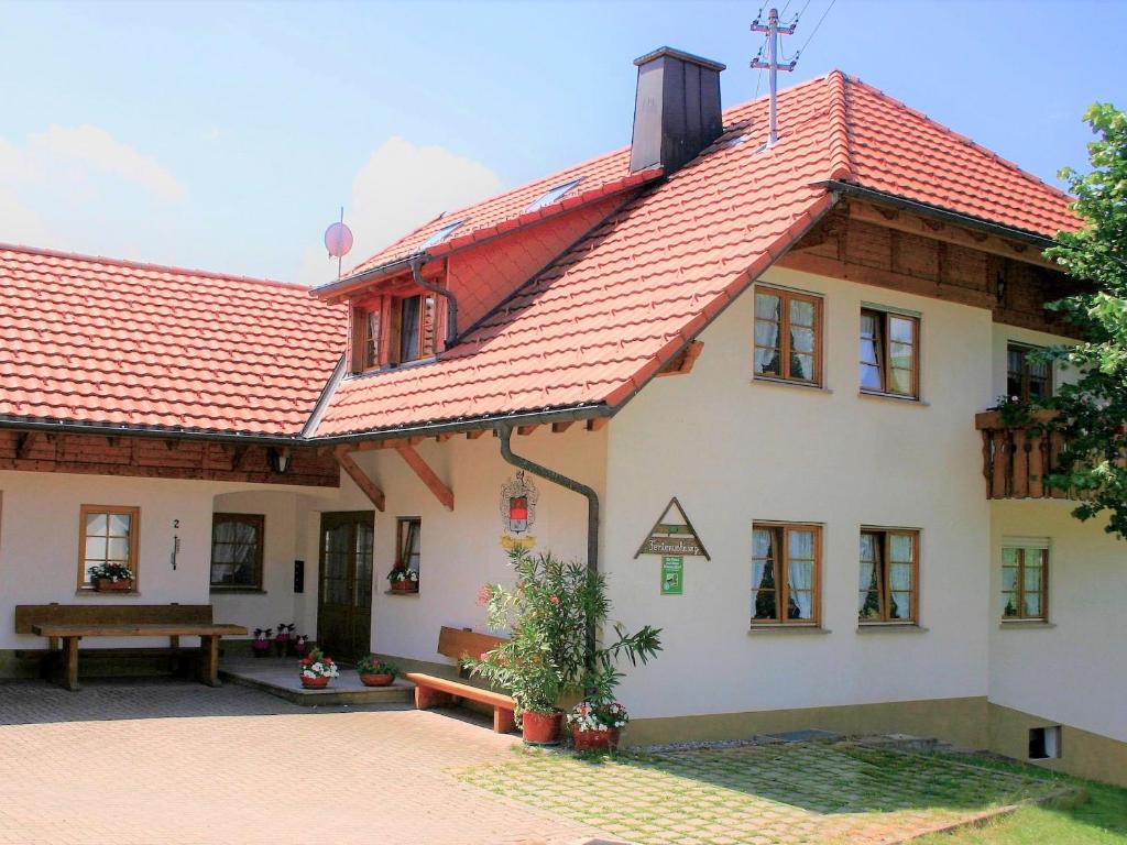 Weilheim的住宿－Ferienwohnung Eckert，红色屋顶和长凳的房子