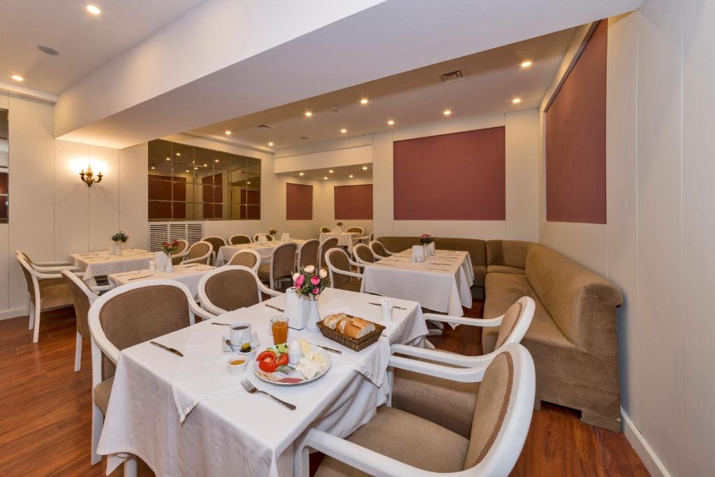 a dining room with white tables and chairs at Febor Park İstanbul Levent Hotel in Istanbul