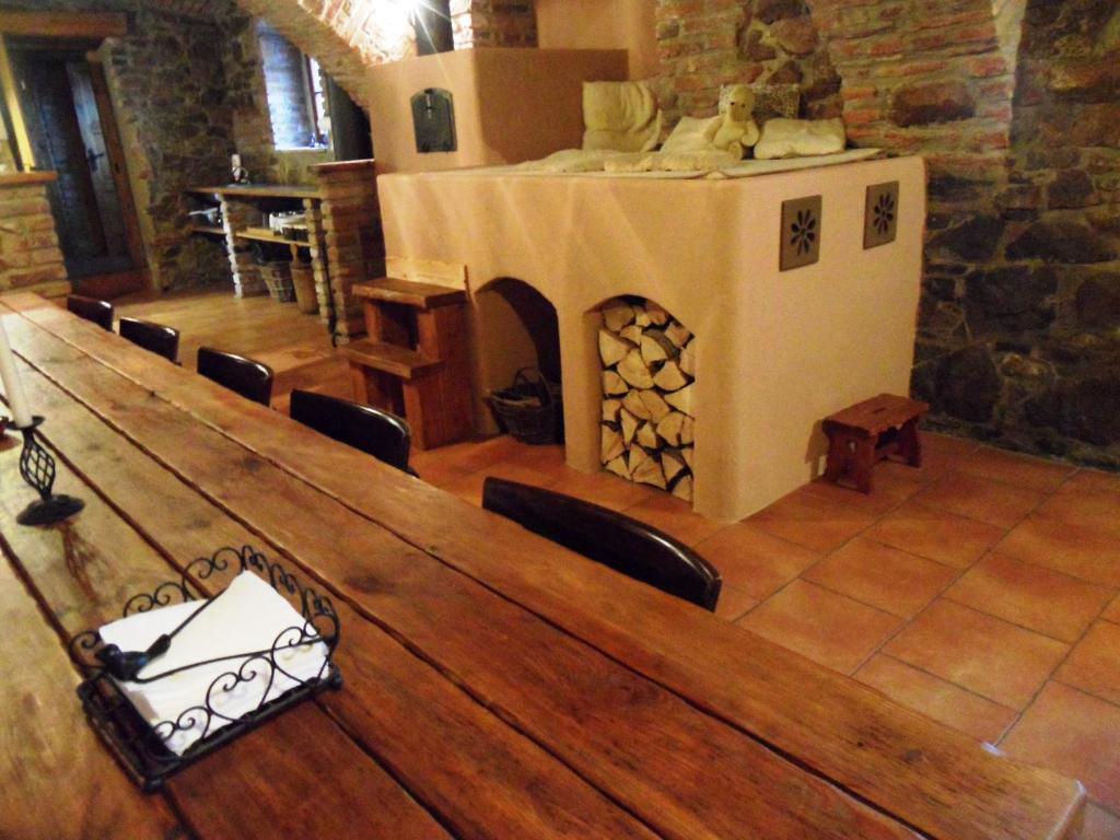 a dining room with a table and a fireplace at Chalupa Budín in Budínek
