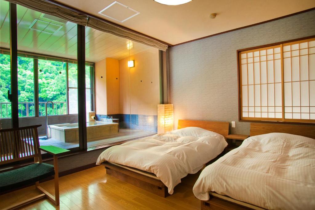 Postel nebo postele na pokoji v ubytování Yamanakaonsen Ohanami Kyubei