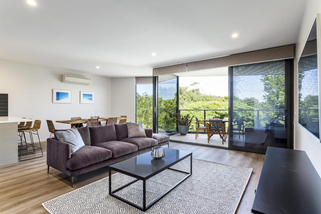 a living room with a couch and a table at Blairgowrie Apartment 2 - on the beach in Blairgowrie