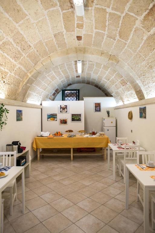 Pokój z białymi stołami i kamiennym sufitem w obiekcie 19Venti w mieście Lecce