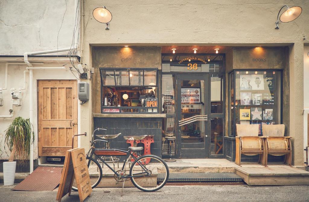 una bicicletta parcheggiata di fronte a un negozio di 36hostel a Hiroshima