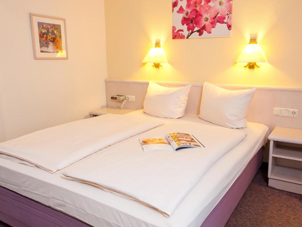 Postel nebo postele na pokoji v ubytování Hotel Traube Rüdesheim