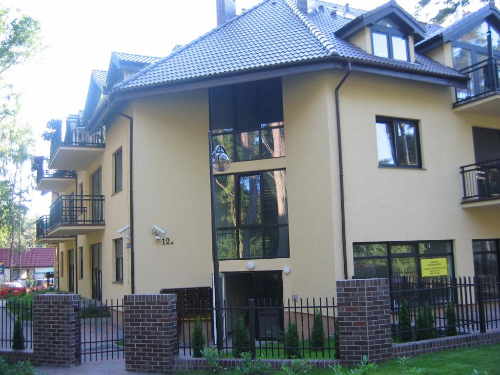 a house with a fence in front of it at Apartment Jola in Pobierowo