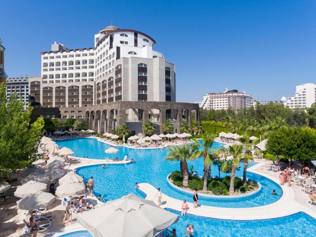 een uitzicht op het zwembad in een hotel met gebouwen op de achtergrond bij Melas Lara Hotel in Lara