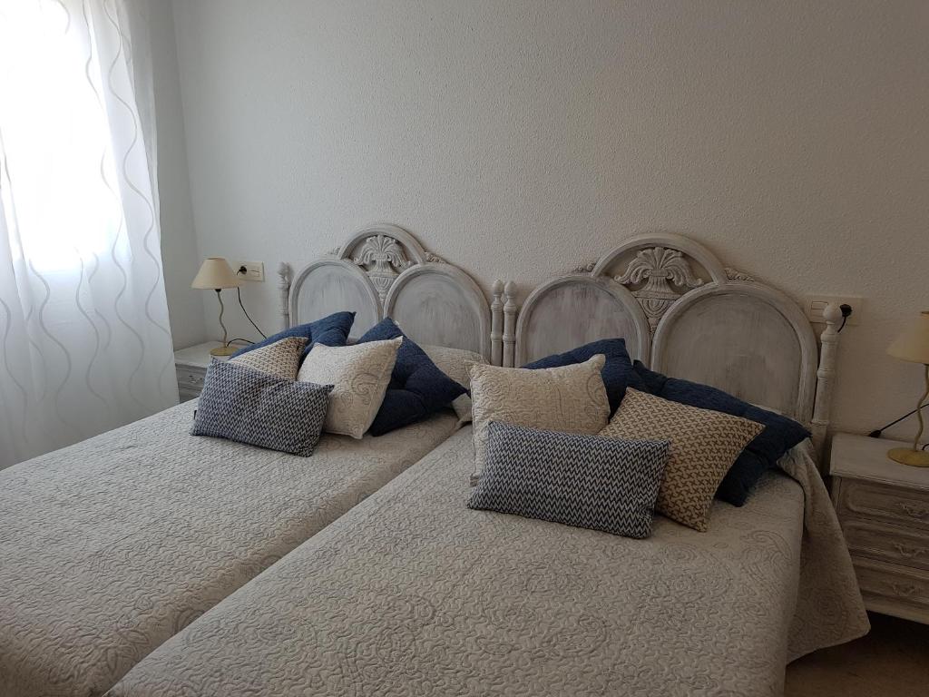 a bedroom with two beds with blue and white pillows at Apartamento centrico in Almuñécar