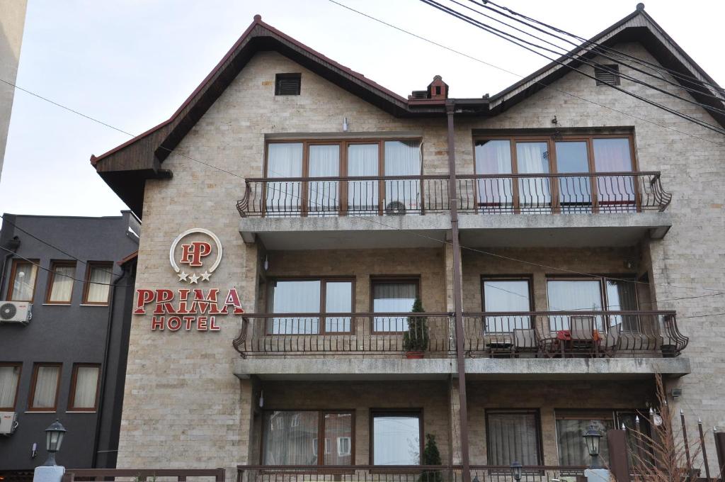 un bâtiment avec un panneau sur son côté dans l'établissement Hotel Prima, à Pristina