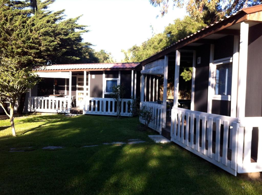 ein Haus mit einem weißen Zaun und einem Hof in der Unterkunft Bungalows Tangana in Tarifa