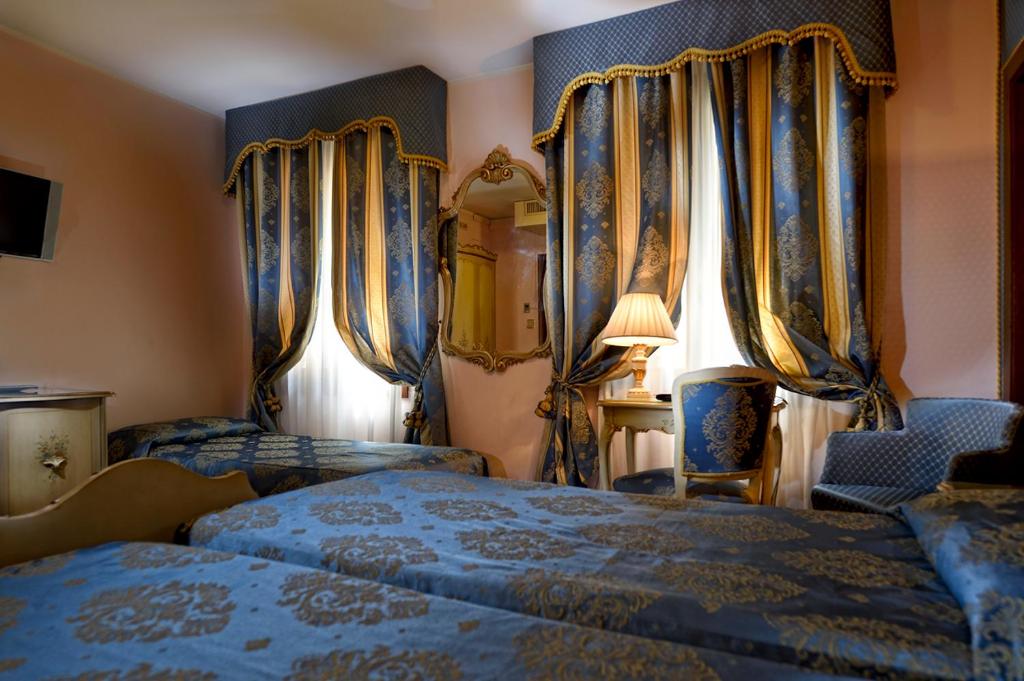 Postel nebo postele na pokoji v ubytování Royal San Marco Hotel