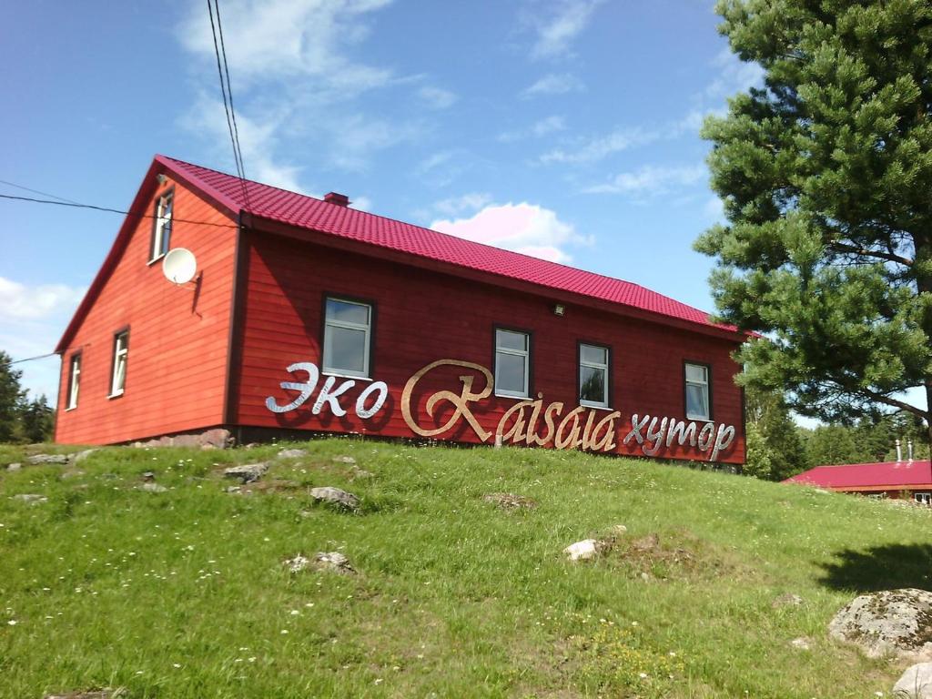 una casa roja con graffiti a un lado. en Эко-хутор "Ряйсяля-Райский Сад", en Mel'nikovo