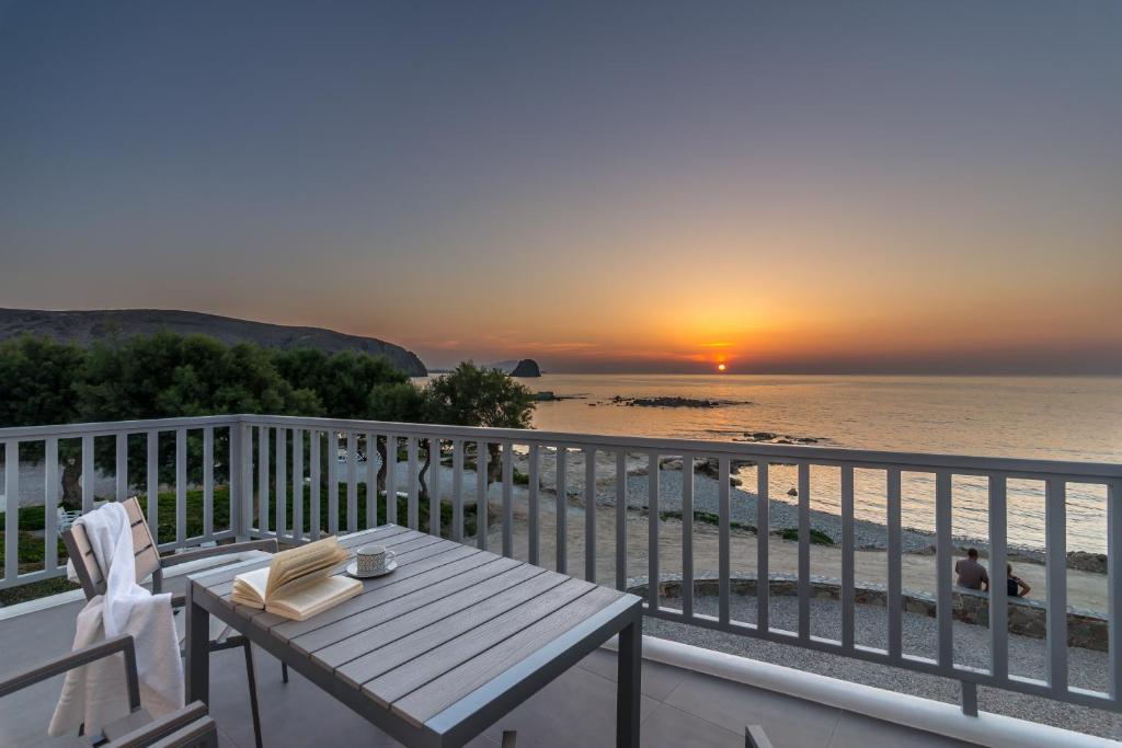 uma mesa e cadeiras numa varanda com vista para o oceano em Milos Waves Luxury Apartments em Pollonia