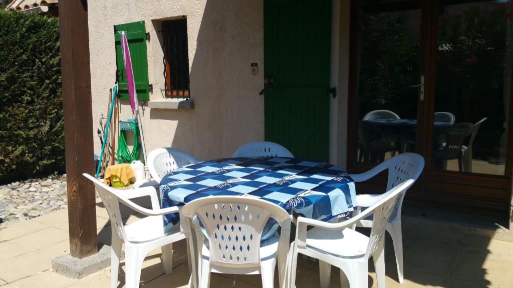 - une table et des chaises bleues et blanches sur la terrasse dans l'établissement Résidence Cap Azur Maison N° 56, à Villeneuve-Loubet
