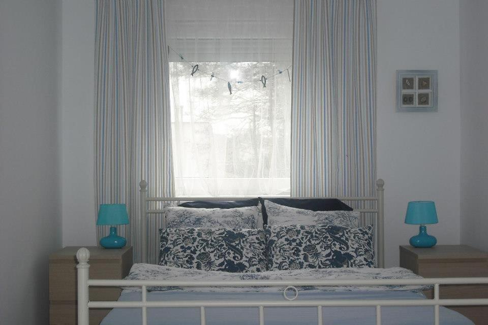 sypialnia z łóżkiem z oknem i 2 lampami w obiekcie Pokoje na wynajem "GRZYBOWO" w Grzybowie