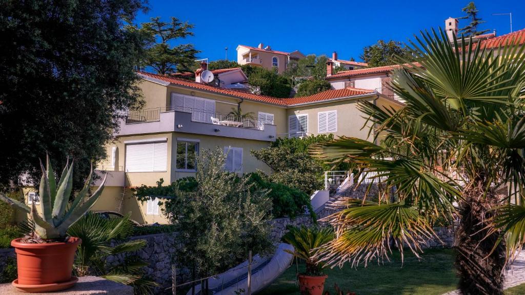 a large house with palm trees in front of it at Braut in Krk