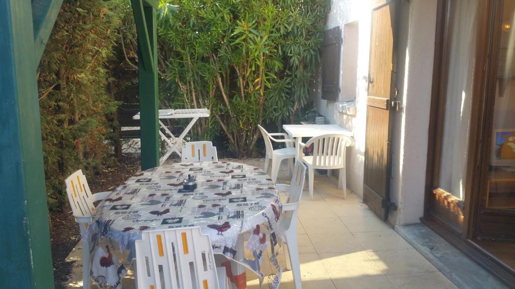 ヴィルヌーヴ・ルベにあるRésidence Cap Azur Maison N° 63の家の外に座るテーブルと椅子