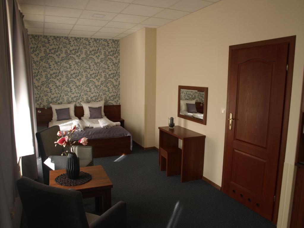 a hotel room with a bed and a table at SanatoriumnadKryniczanką in Krynica Zdrój