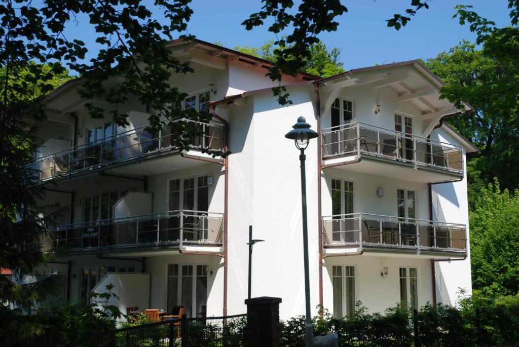 um edifício branco com varandas e uma luz de rua em Strandwohnungen Sellin - WG04 mit 2 Balkonen em Ostseebad Sellin