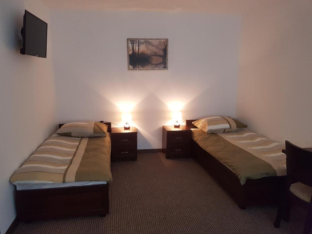 2 camas en una habitación con 2 luces encendidas en Apartament Parkowy, en Brwinów