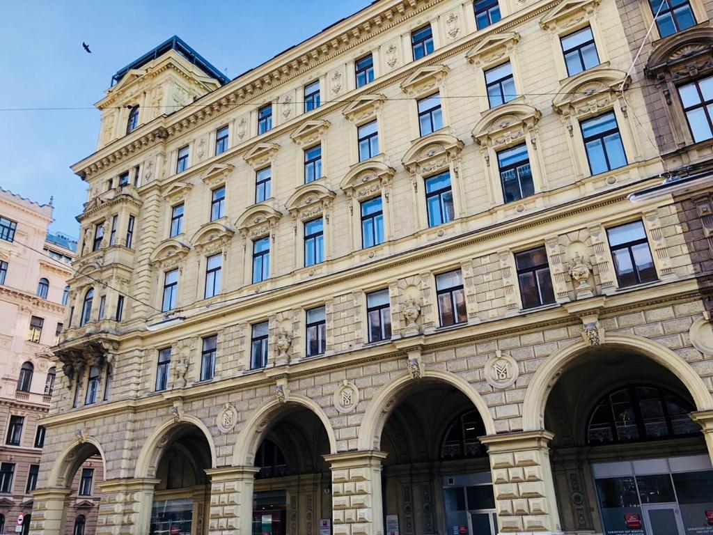 un gran edificio de piedra con muchas ventanas en una calle en KH Apartments Universitaet, en Viena