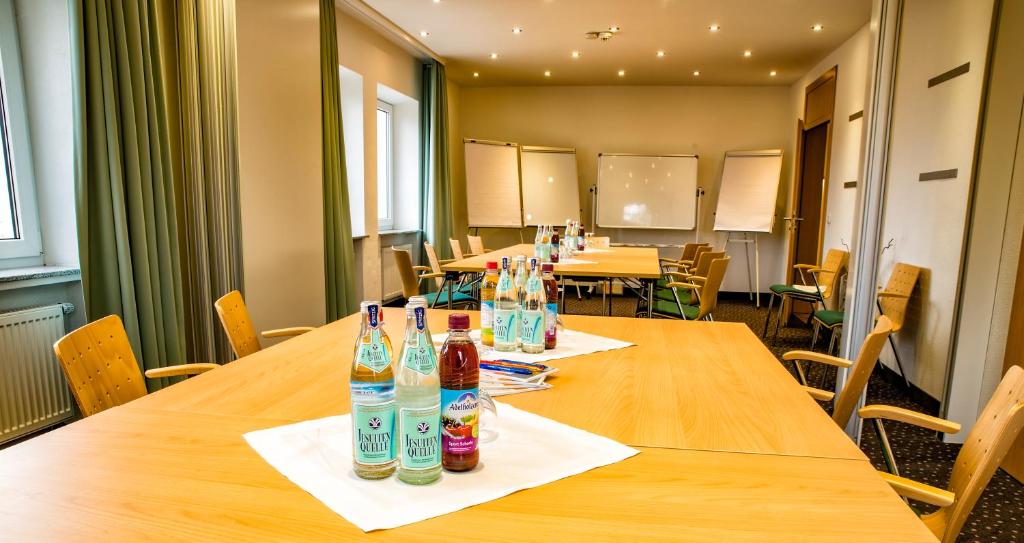 einen Konferenzraum mit einem langen Tisch mit Sodaflaschen in der Unterkunft Hotel Bayerisch Meran in Bad Feilnbach