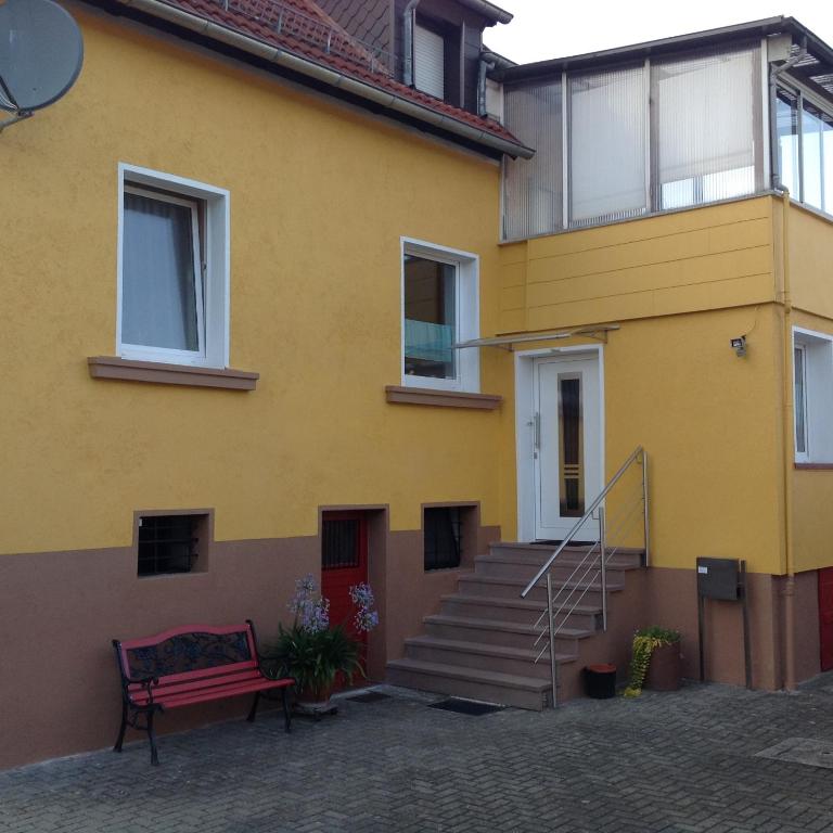 a yellow house with a bench in front of it at Feriendomizil strasser in Homburg
