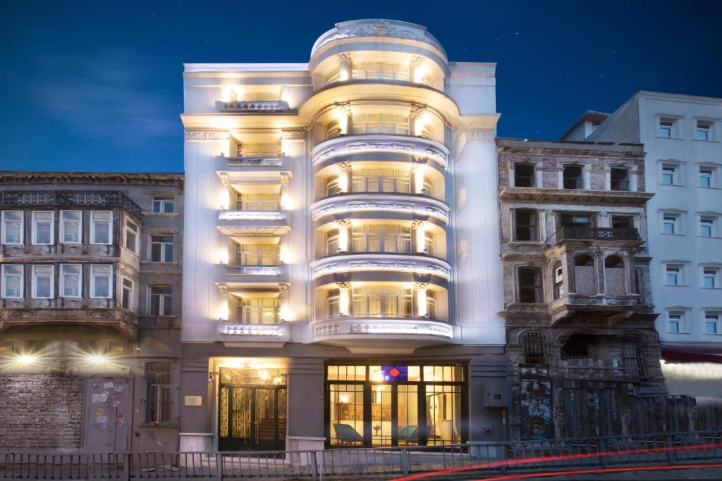 Lina Hotel Taksim Pera في إسطنبول: مبنى أبيض طويل مع أضواء تعمل