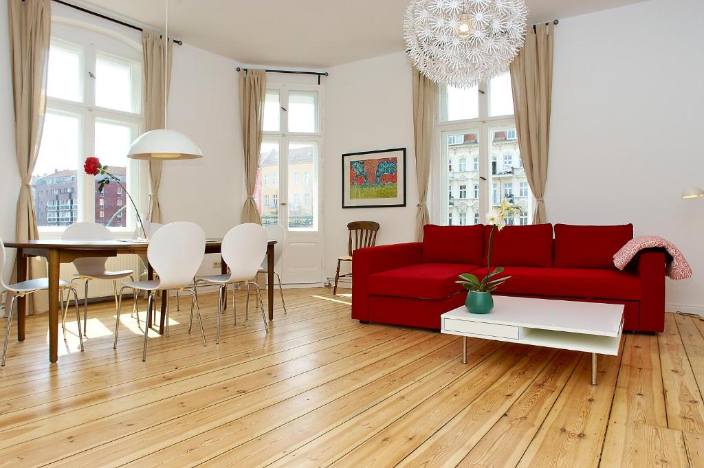 een woonkamer met een rode bank en een tafel bij Apartment Prenzlauer Allee in Berlijn