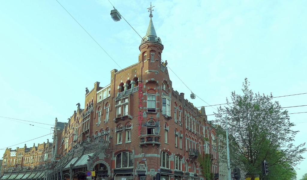 un grand bâtiment en briques rouges avec une tour en haut dans l'établissement Nadia Hotel, à Amsterdam