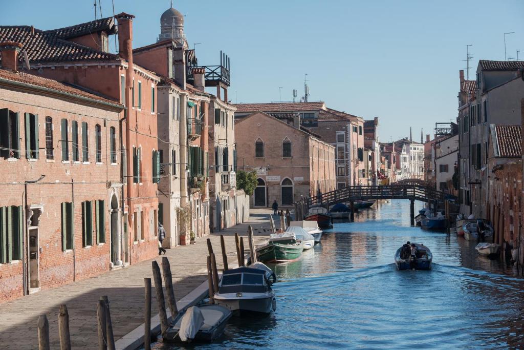 un canal con barcos en el agua entre edificios en ART PAINTING apartment with canal view en Venecia