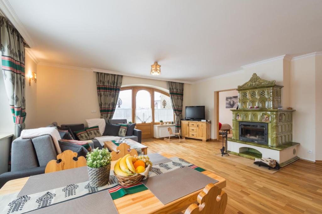 a living room with a table and a fireplace at Apartment Tatrachata in Kościelisko