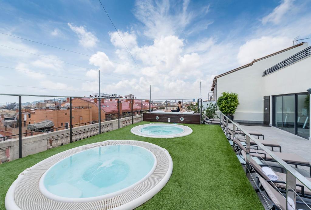 a patio area with a pool and lawn chairs at Hotel Barcelona Center in Barcelona
