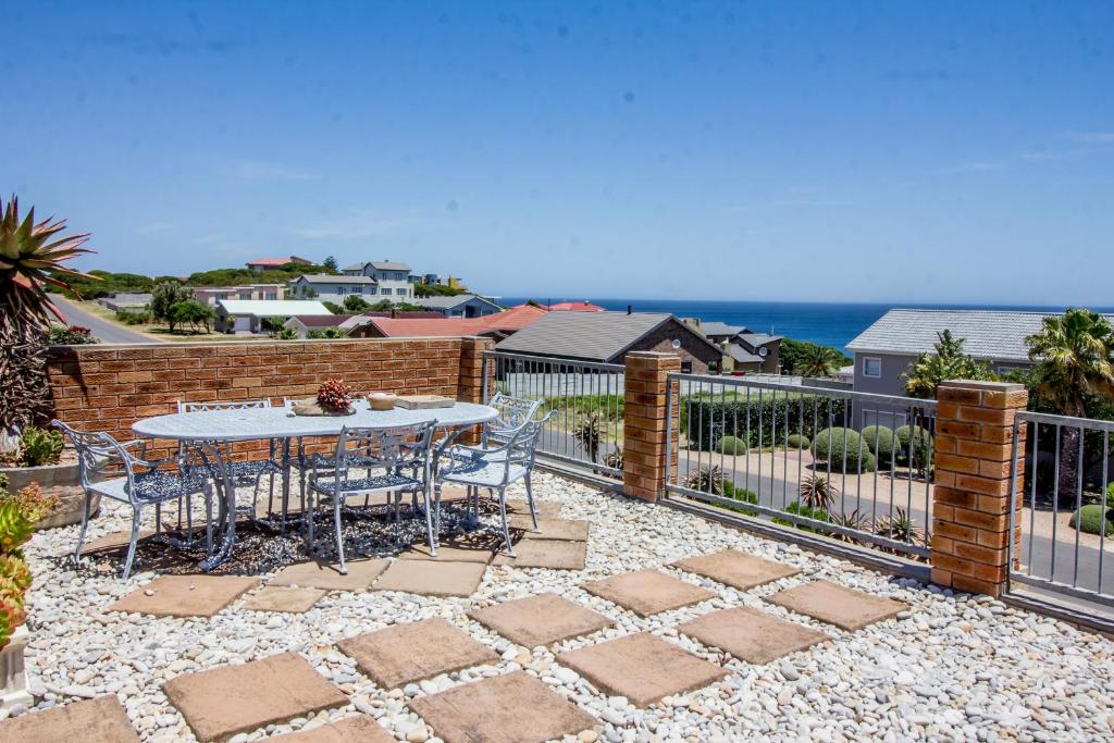 a patio with a table and chairs and the ocean at Walkerview Apartments in Gansbaai