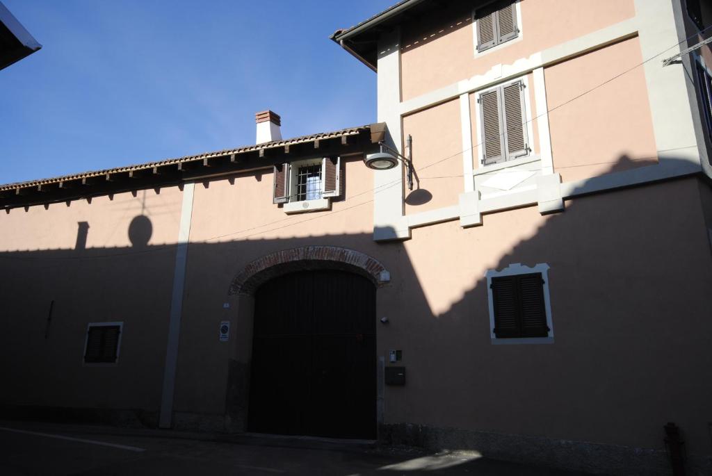 Un edificio con una porta e un'ombra sul lato di Appartamenti Old Farm a Vaprio dʼAgogna