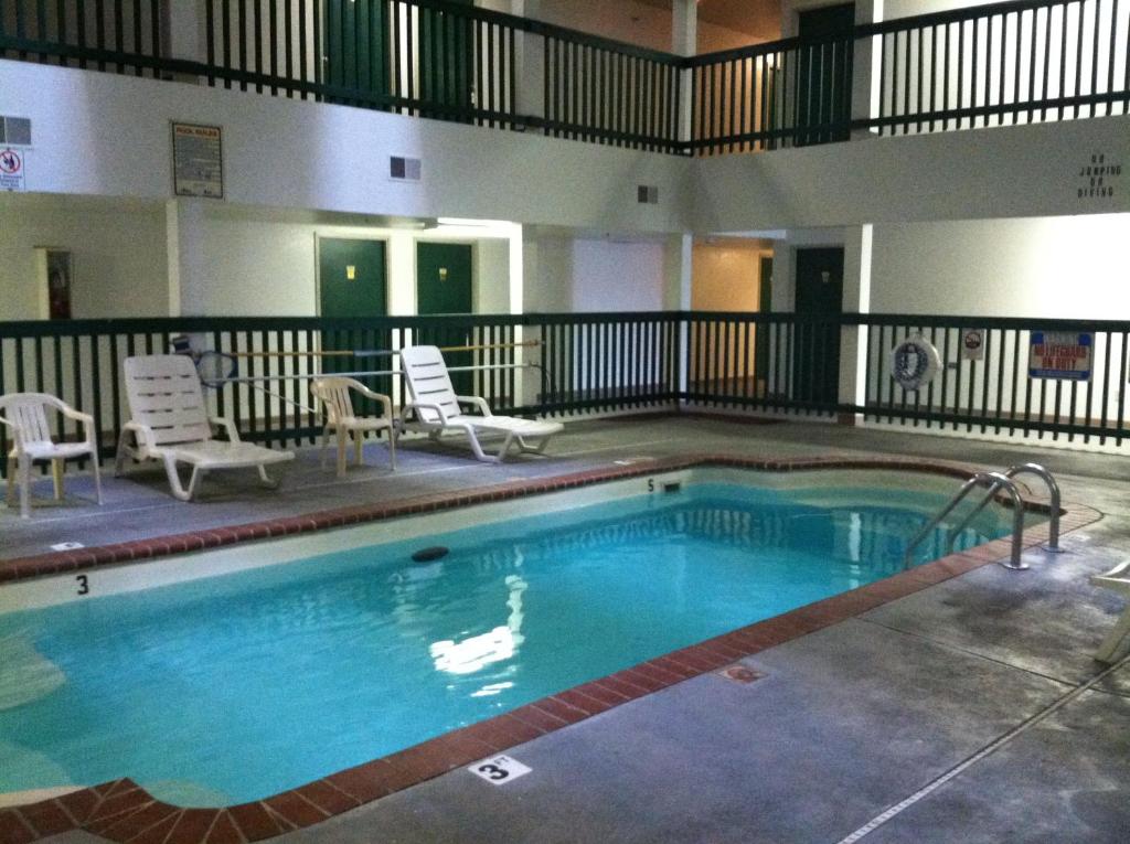a large swimming pool in a hotel with chairs at Budget Inn Wentzville in Wentzville