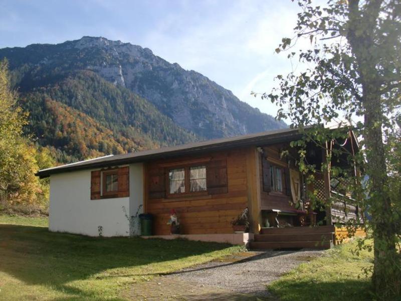 a wooden house with a mountain in the background at Ferienalm in Ruhpolding