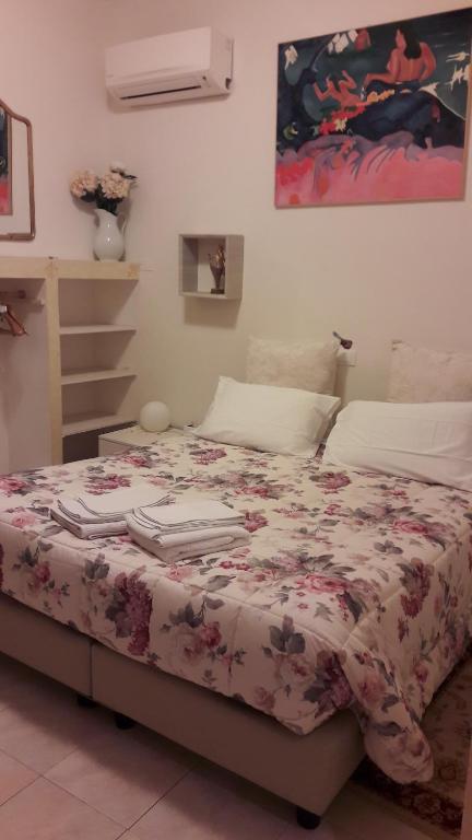 a bedroom with a bed with a floral bedspread at Sottoriva36 in Verona