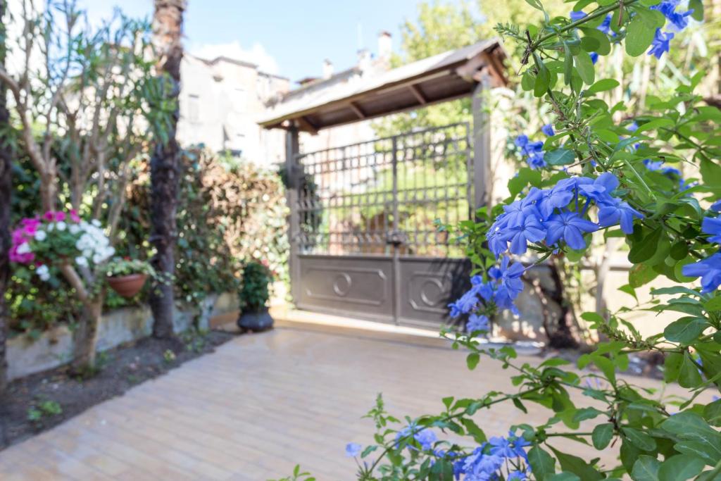 un jardín con una puerta y flores azules en B&B La Bragadina, en Lido de Venecia