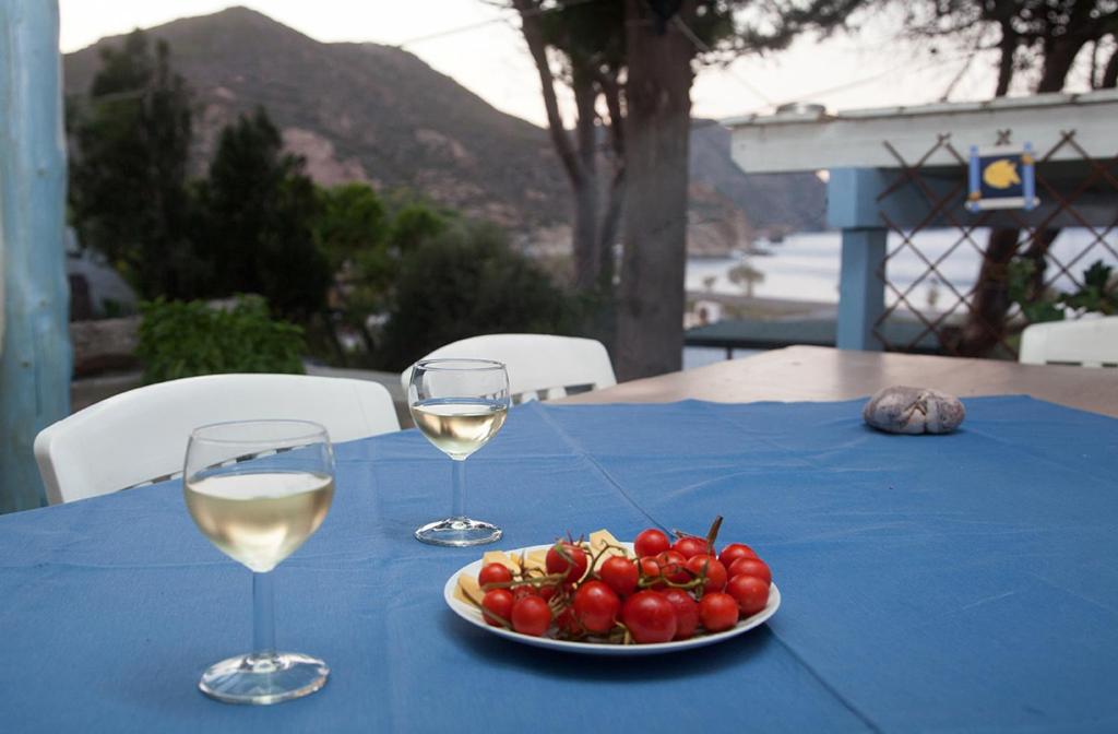 a table with two glasses of wine and a plate of fruit at Lampi's House in Patmos