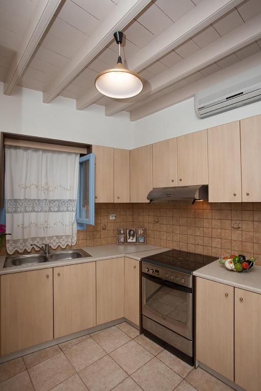 a kitchen with wooden cabinets and a stove top oven at Lampi's House in Patmos