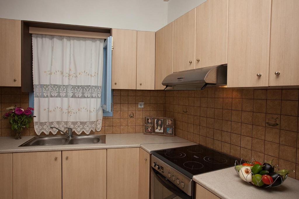 a kitchen with a sink and a stove and a window at Lampi's House in Patmos