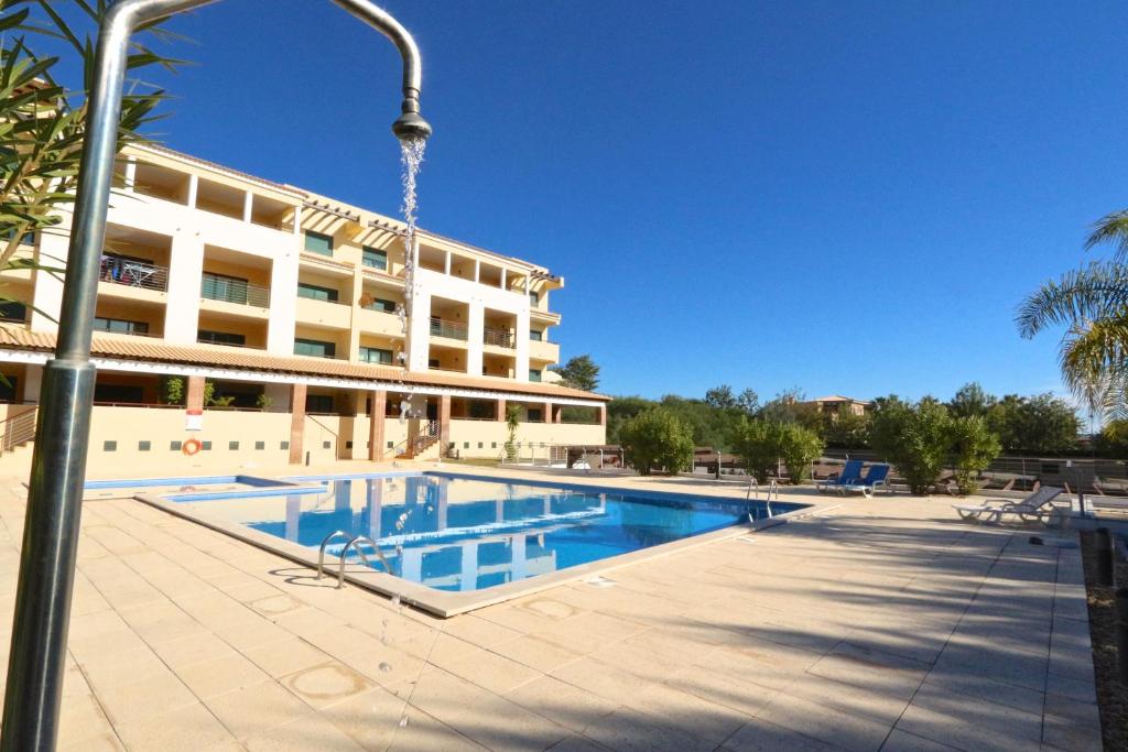 une piscine en face d'un bâtiment dans l'établissement Terraços de Vilamoura 55- Clever Details, à Vilamoura