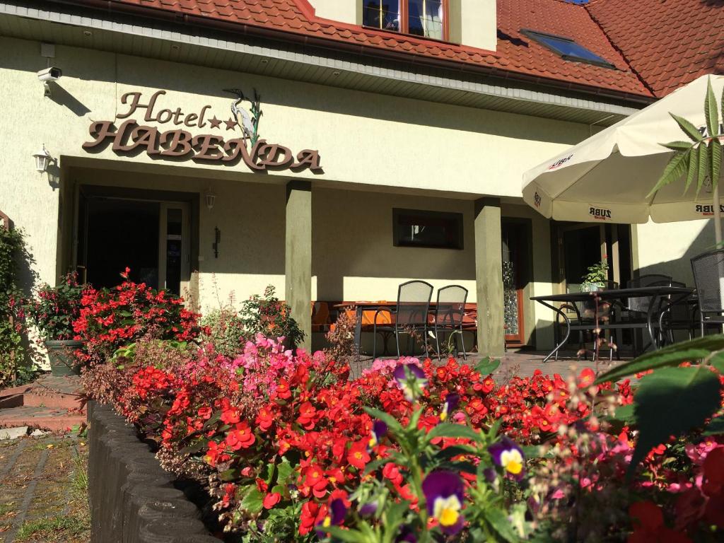 a bunch of flowers in front of a restaurant at Hotel Habenda in Krutyń