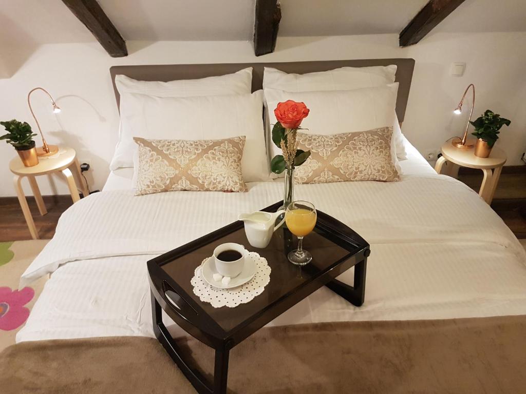 un letto con un tavolo con un vaso con una rosa sopra di Mickey Mouse Supilova 24 a Zagabria