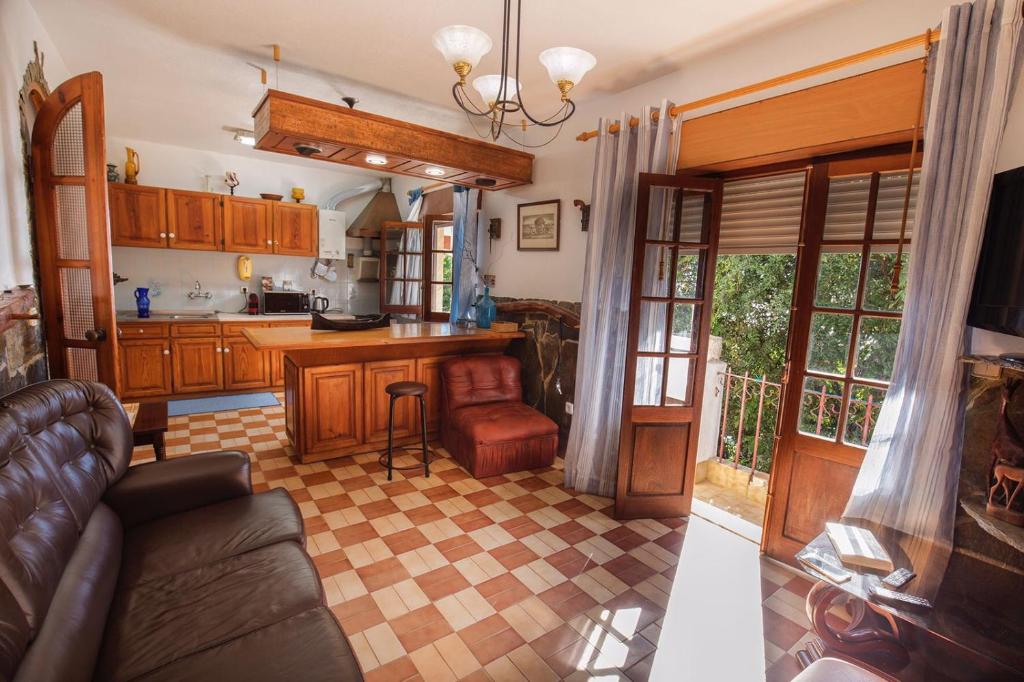 uma sala de estar com um sofá e uma cozinha em Fonte da telha Beach House em Costa da Caparica