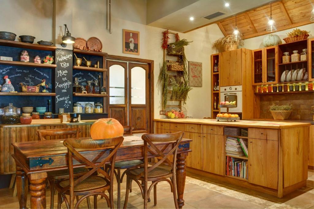 a kitchen with a wooden table and chairs at Gastronomy Hotel Kritsa in Portaria