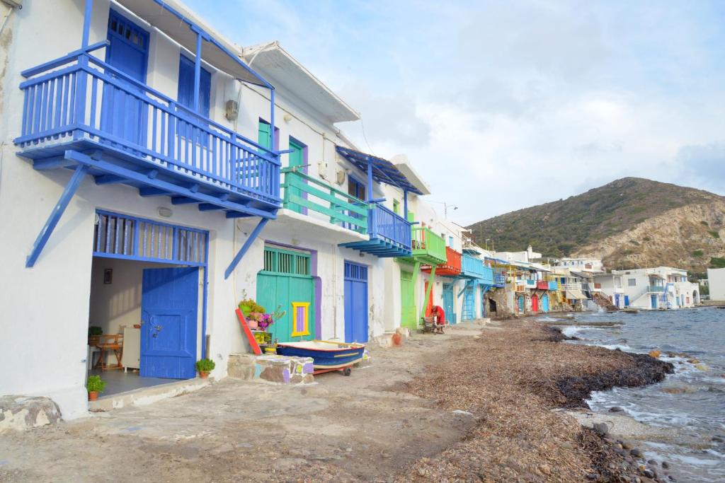 une rangée de maisons avec des portes bleues dans une rue dans l'établissement Blue Sea House, à Klima