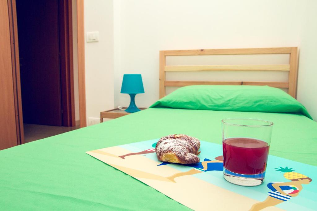 talerz jedzenia i szklankę soku na łóżku w obiekcie Casa Stoccolma w mieście Pozzallo